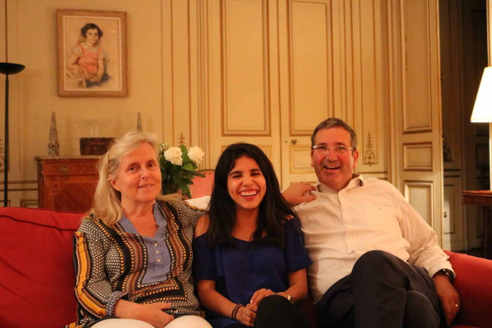 Host family sitting with guest student in living room smiling | Host Family Stay