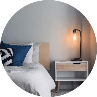 bed and night table with lamp | Host Family Stay